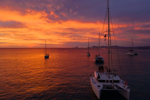 Boats anchored against a vivid lake sunset