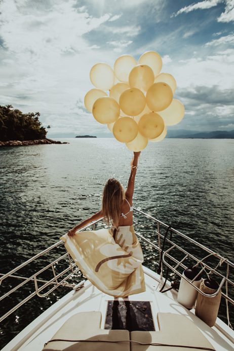 Guest holding balloons against the lake horizon